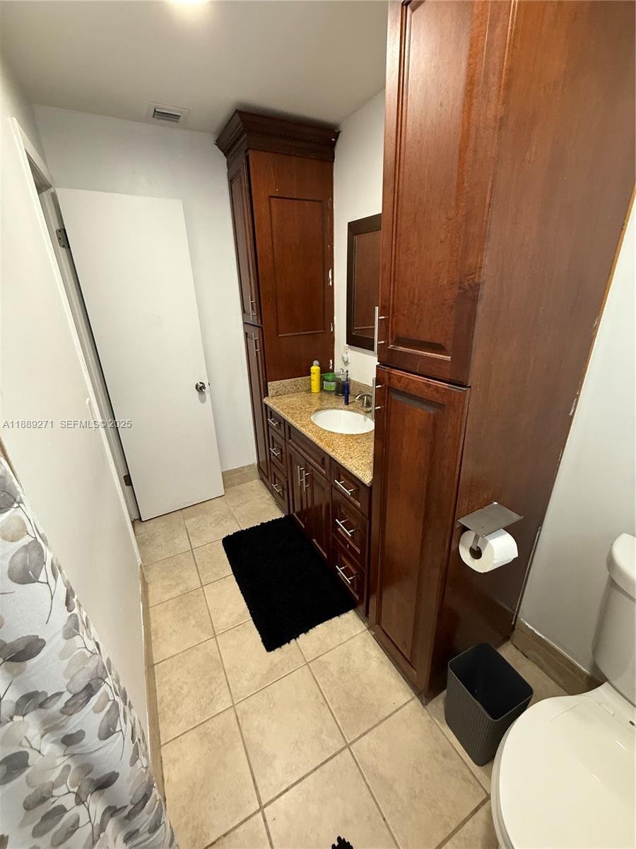 13060 Southwest 263rd Terrace Homestead, FL 33032 - Photo 21 of 30 a bathroom with a toilet a sink and mirror