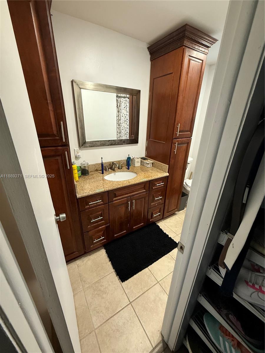 13060 Southwest 263rd Terrace Homestead, FL 33032 - Photo 23 of 30 a bathroom with a sink a toilet a mirror and vanity