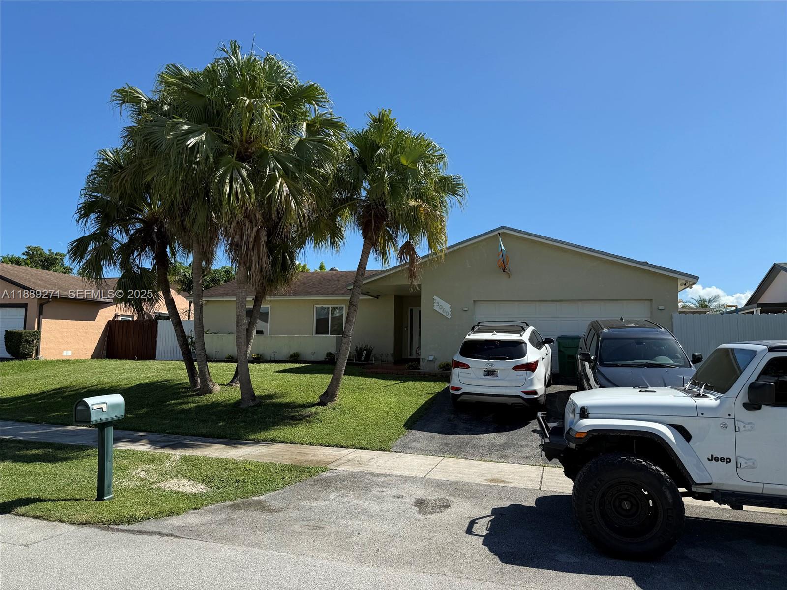 13060 Southwest 263rd Terrace Homestead, FL 33032 - Photo 3 of 30 a view of a car parked in front of a house with a yard