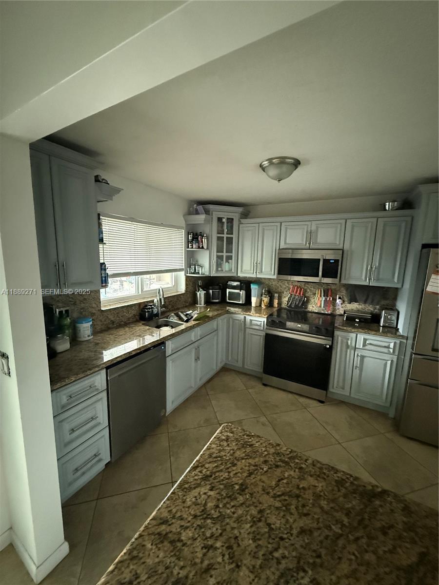 13060 Southwest 263rd Terrace Homestead, FL 33032 - Photo 10 of 30 a kitchen with a sink counter top space appliances and cabinets