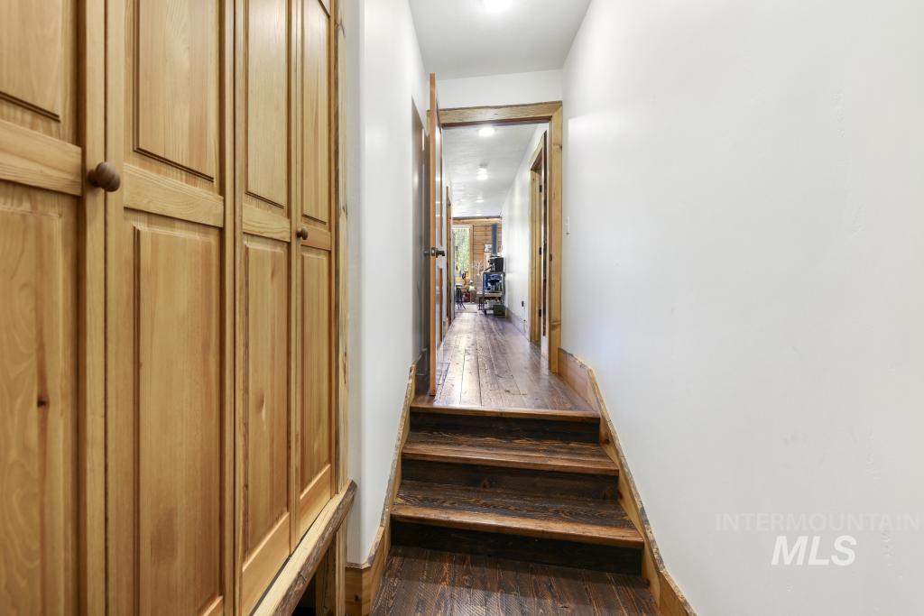65 Goat Creek Way Stanley, ID 83278 - Photo 25 of 32 Hallway featuring built-in wood cabinetry, wood-finish flooring, and natural wood trim around doorways and baseboards