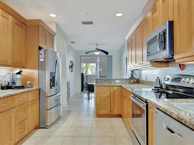 a kitchen with stainless steel appliances granite countertop a sink stove and refrigerator