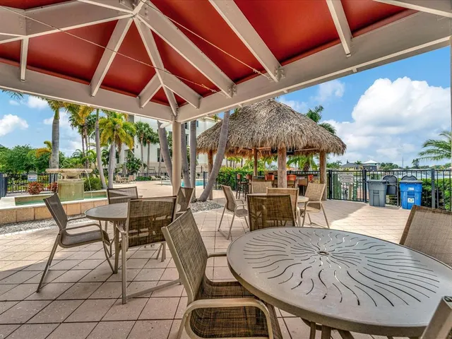 a view of a patio with a table and chairs under an umbrella
