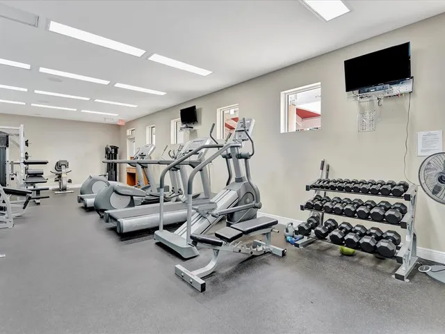 a room with gym equipment and a flat screen tv