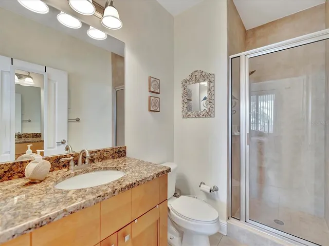 a bathroom with a granite countertop sink toilet and shower