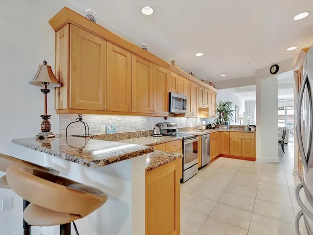 a kitchen with stainless steel appliances granite countertop a sink counter space cabinets and a large window