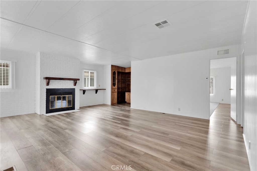 15252 Seneca Road, Unit 241 Victorville, CA 92392 - Photo 11 of 30 a view of an empty room with wooden floor fireplace and a window