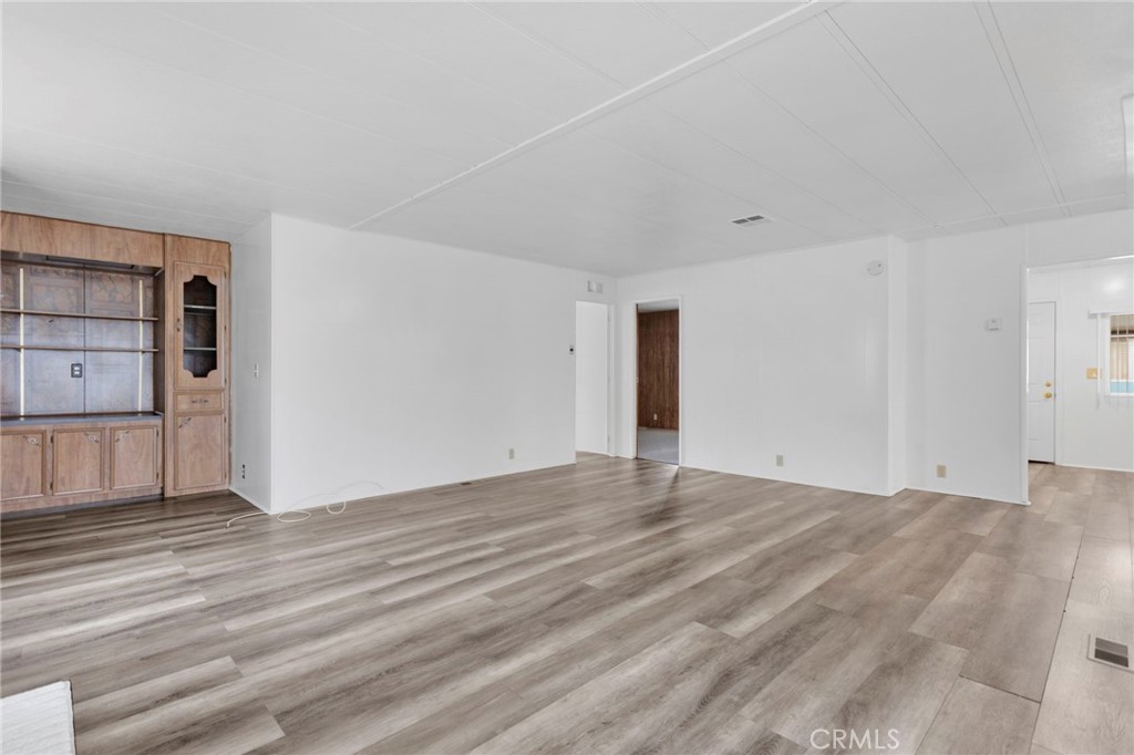 15252 Seneca Road, Unit 241 Victorville, CA 92392 - Photo 14 of 30 a view of an empty room with window and wooden floor