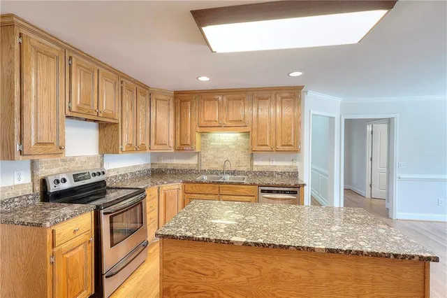 a kitchen with stainless steel appliances granite countertop wooden cabinets and a granite counter tops