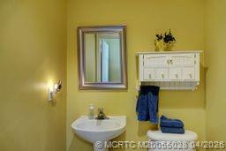 2120 Northwest Marsh Rabbit Lane Jensen Beach, FL 34957 - Photo 33 of 34 a bathroom with a sink and a mirror
