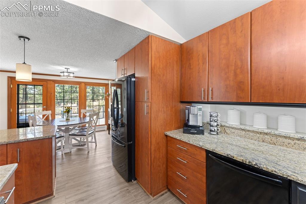 1851 Buttercup Road Elizabeth, CO 80107 - Photo 19 of 47 a kitchen with stainless steel appliances granite countertop a refrigerator a sink dishwasher and wooden cabinets with wooden floor