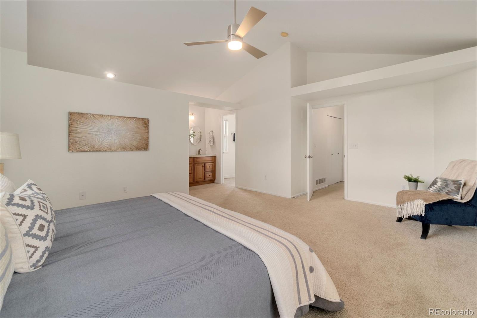 9752 Quay Loop Westminster, CO 80021 - Photo 16 of 27 a spacious bedroom with a bed and a chair