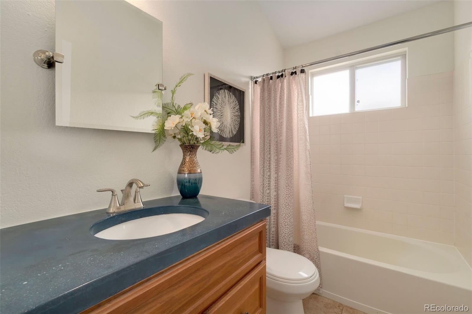 9752 Quay Loop Westminster, CO 80021 - Photo 20 of 27 a bathroom with a granite countertop sink a toilet and shower