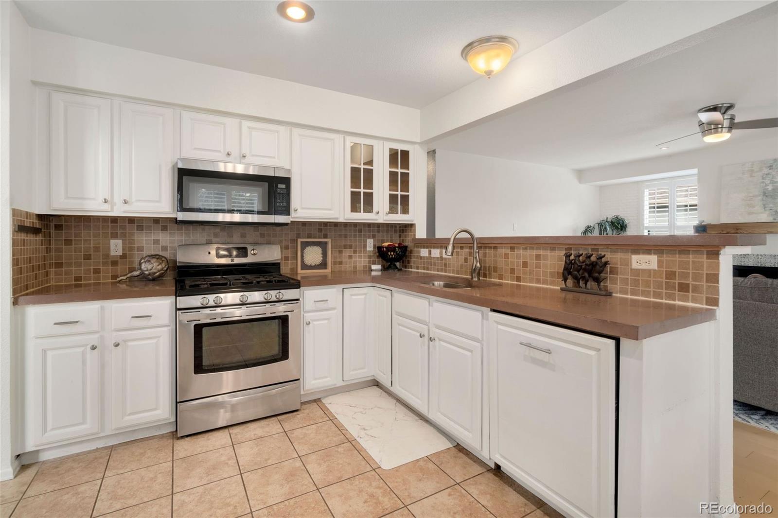 9752 Quay Loop Westminster, CO 80021 - Photo 7 of 27 a kitchen with stainless steel appliances granite countertop a sink and cabinets