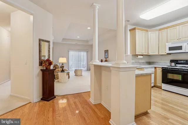 a kitchen with stainless steel appliances granite countertop a stove a sink dishwasher a refrigerator and cabinets with wooden floor