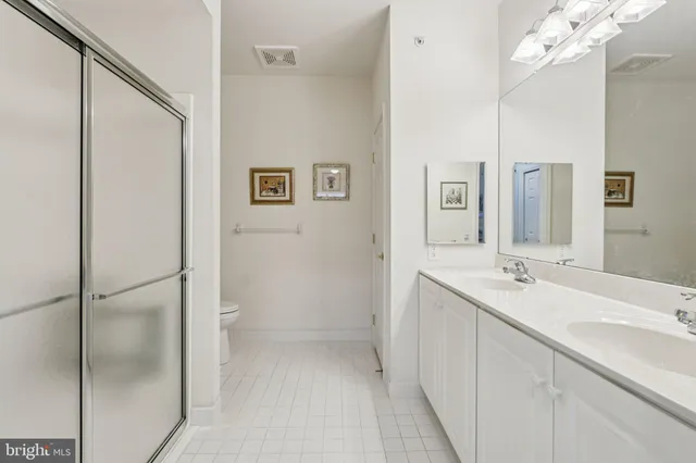 a bathroom with a double vanity sink mirror and shower