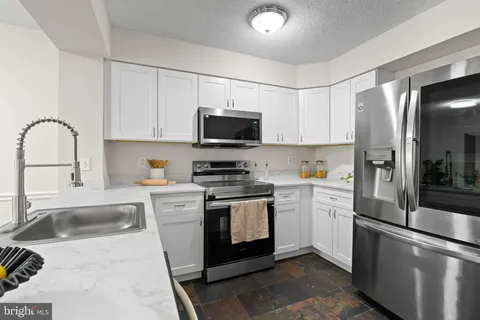 a kitchen with stainless steel appliances granite countertop a sink and a microwave