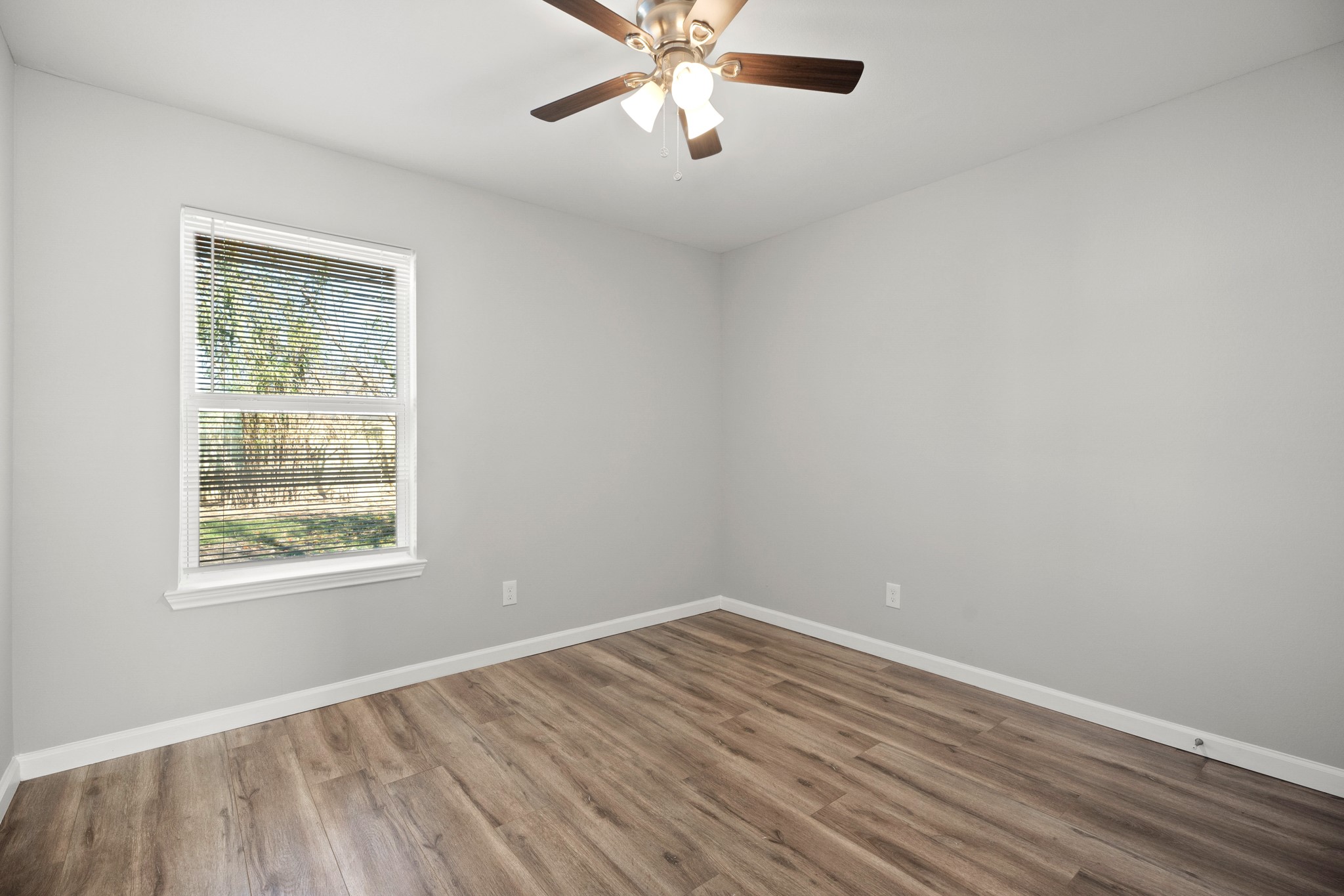 5123 Ridgeway Drive Houston, TX 77033 - Photo 13 of 21 Secondary bedroom with vinyl plank floors, a window with privacy blind, a ceiling fan, and a built-in closet.