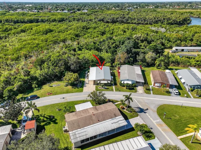 an aerial view of residential houses with outdoor space and trees