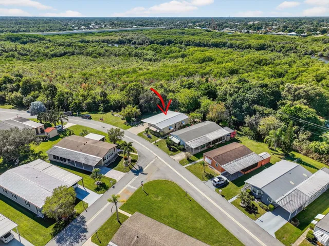 an aerial view of residential houses with outdoor space and trees