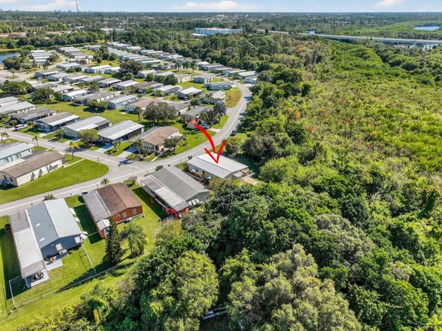 an aerial view of residential houses with outdoor space and trees