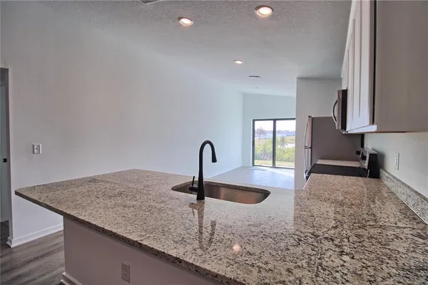 a kitchen with kitchen island a sink and a stove