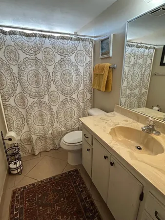 a bathroom with a granite countertop toilet sink and mirror