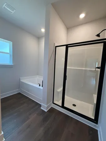 a view of an empty room with wooden floor and door