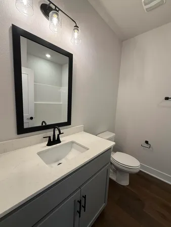 a bathroom with a sink a toilet and mirror