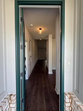 a view of a hallway with wooden floor and furniture