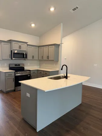 a view of kitchen with stainless steel appliances granite countertop a sink and a stove top oven