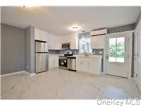a kitchen with white cabinets and appliances