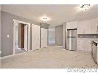 a view of a kitchen with a refrigerator wooden cabinets