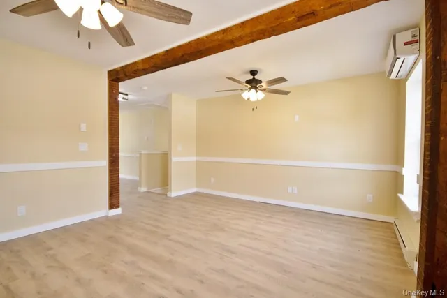 a view of an empty room with a chandelier fan