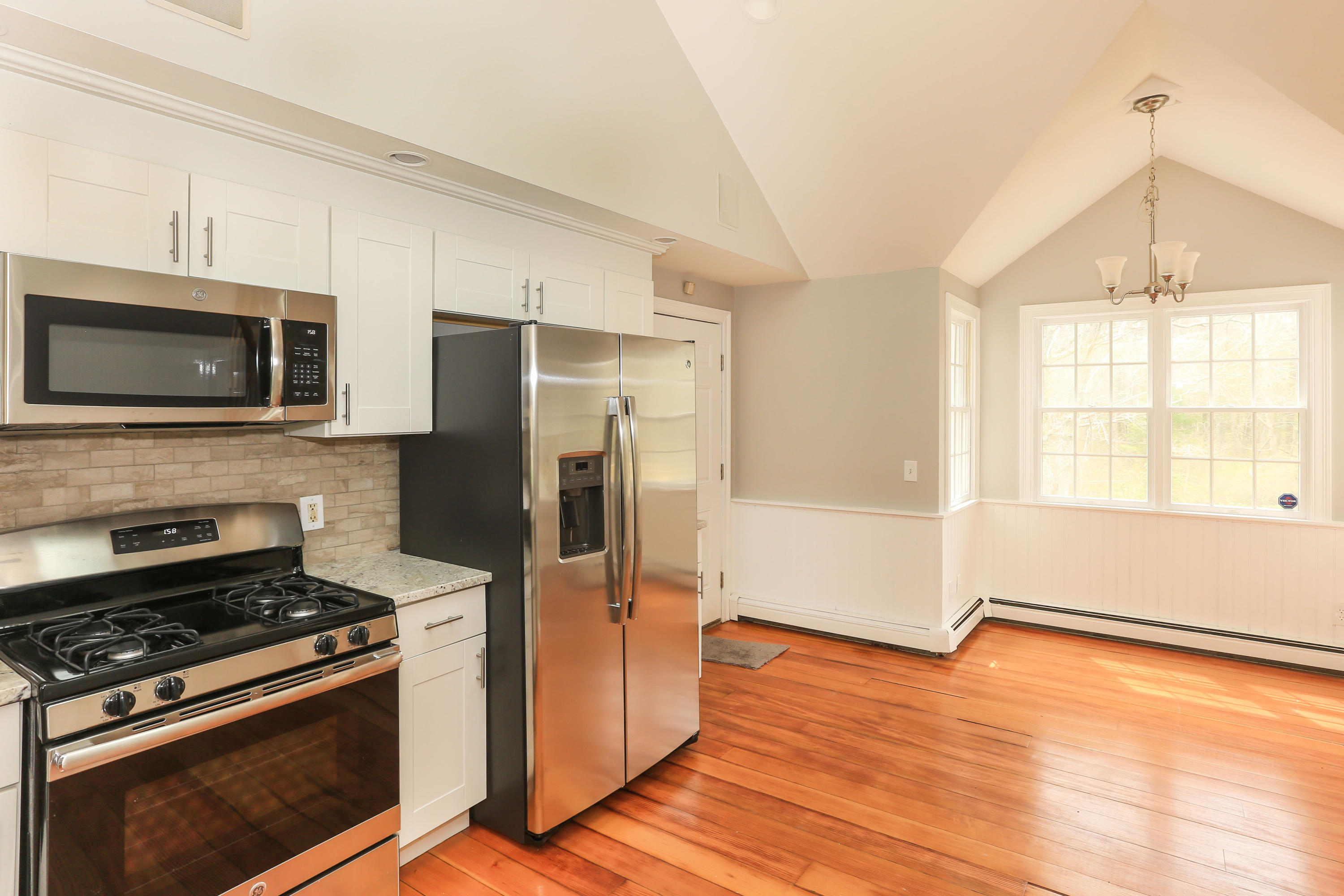 161 River Road Marstons Mills, MA 02648 - Photo 4 of 17 a kitchen with stainless steel appliances a stove a microwave and a hard wood floor