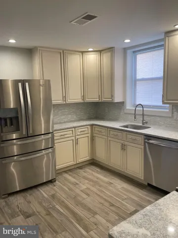 a kitchen with stainless steel appliances granite countertop a refrigerator sink and cabinets