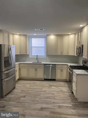 a large kitchen with stainless steel appliances granite countertop a stove a sink and a refrigerator