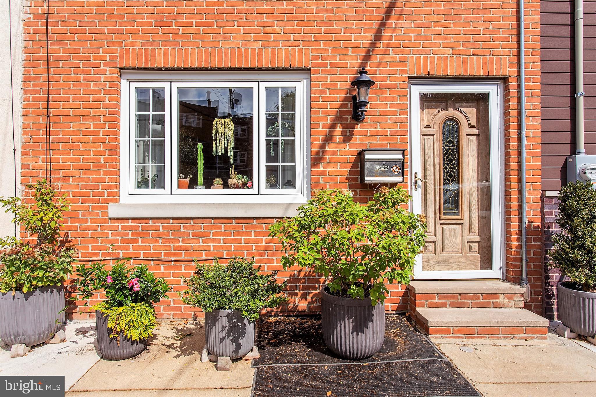 a view of a brick house with potted plants