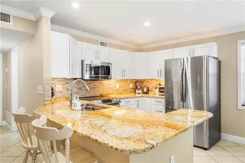 a kitchen with stainless steel appliances granite countertop a sink and a refrigerator