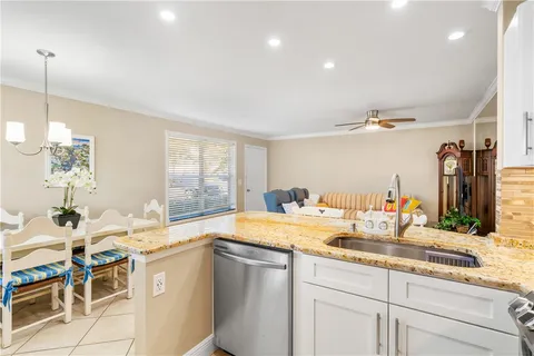 a kitchen with granite countertop a sink and white cabinets