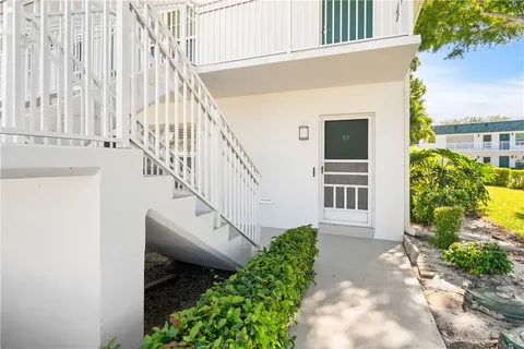 a view of a house with a small yard and potted plants