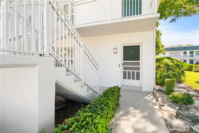 a view of a house with a small yard and potted plants