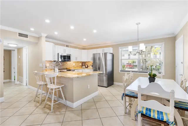 a kitchen with a dining table chairs appliances and cabinets