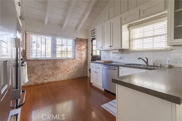 a kitchen with granite countertop a sink stainless steel appliances and cabinets