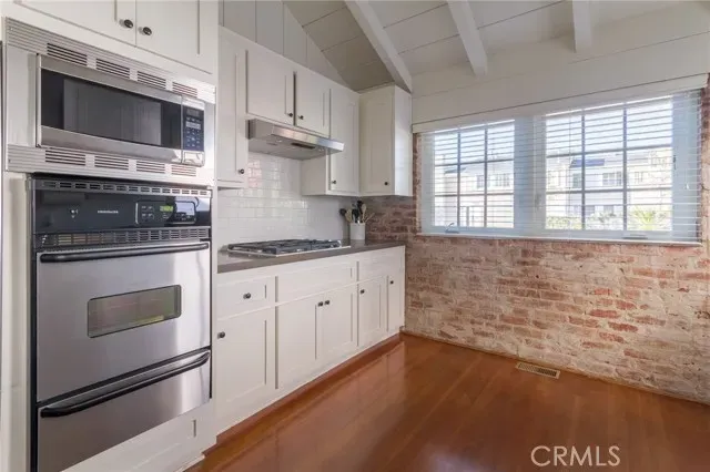 a kitchen with stainless steel appliances kitchen island granite countertop a stove microwave and sink