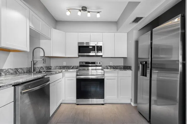 a kitchen with a sink stainless steel appliances and cabinets
