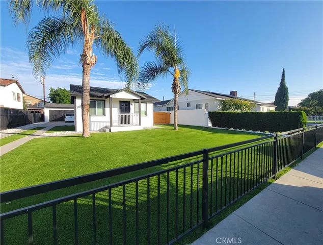 a view of a house with a yard and potted plants