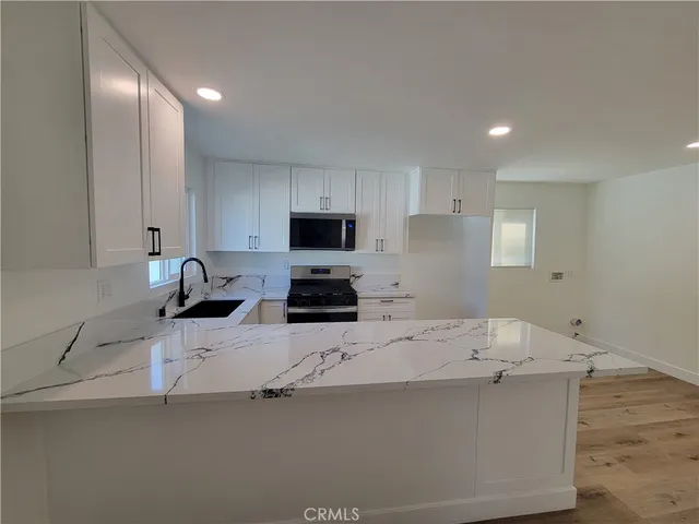 a kitchen with a sink a microwave and cabinets