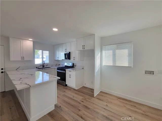 a kitchen with white cabinets and stainless steel appliances