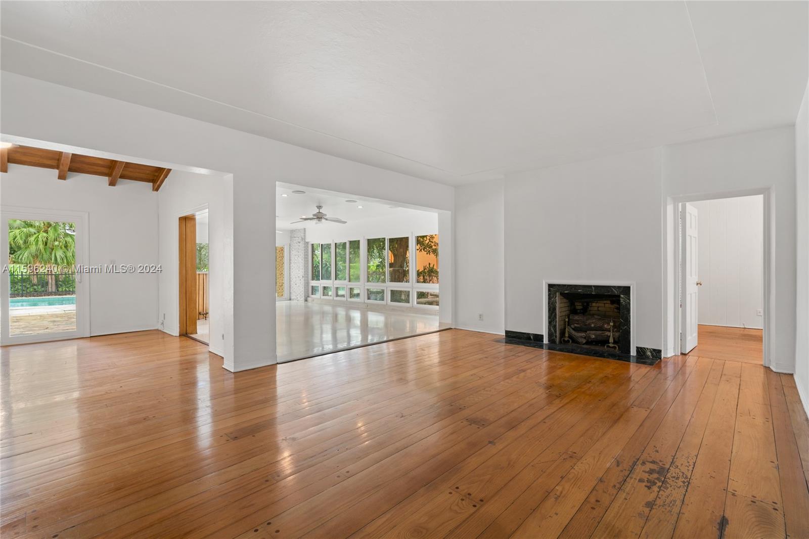 5311 Alton Road Miami Beach, FL 33140 - Photo 12 of 51 a view of an empty room with wooden floor fireplace and a window
